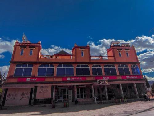 een groot rood gebouw met veel ramen bij Bio Palace Hotel in Tinerhir