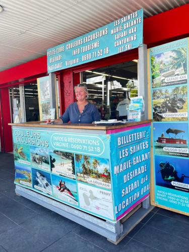 a woman standing behind a counter in a store at Azuri Lodge Duplex Marina in Saint-François