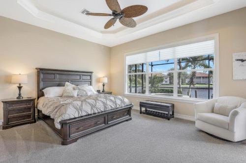 a bedroom with a bed and a ceiling fan and a window at Stunning home with pool, spa and huge waterview in Marco Island