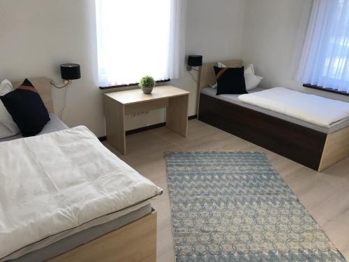 Cette petite chambre comprend deux lits et une table. dans l'établissement Spreewälder Ferienhäuser am Berste - Ufer, à Lübben