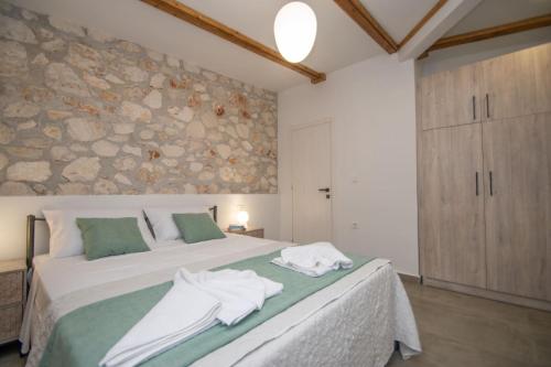 a bedroom with a large bed with towels on it at Green Oak Villa in Orthoniaí