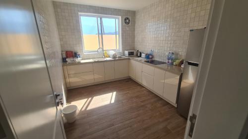 a small kitchen with a sink and a window at Casa Del Mar Villa in As Sīfah