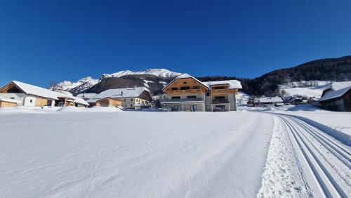 a snow covered road with houses in the background at Moamoosgut in Göriach