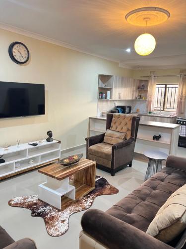 a living room with a couch and a table at Hibiscus Apartments in Ndola