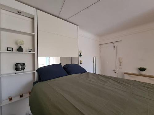 um quarto com uma cama grande e almofadas azuis em Studio à 2 pas de la gare em Sartrouville