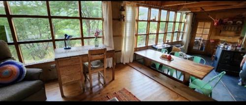 a living room with a counter and a kitchen with windows at Casa del río in Cochrane