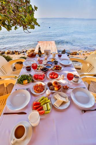 a table with plates of food on the beach at Club Hotel Gultur in Kucukkuyu