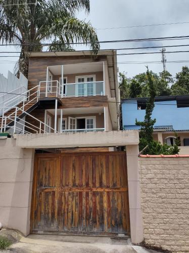a house with a wooden gate and a garage at Apartamentos Aconchegantes Bingen em Petrópolis in Petrópolis