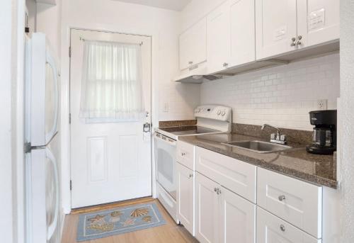 a white kitchen with a sink and a white refrigerator at Beach Plum Resort in Montauk