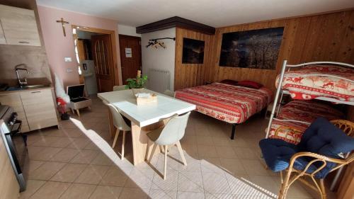 a bedroom with a bed and a table and chairs at Residenze Vezza - La Corteccia- in Vezza dʼOglio