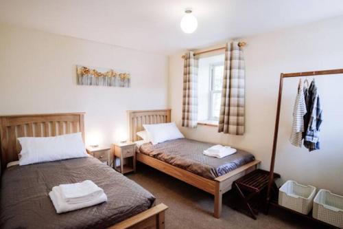 um quarto com 2 camas e uma janela em Stockman's Cottage em Kirkcudbright