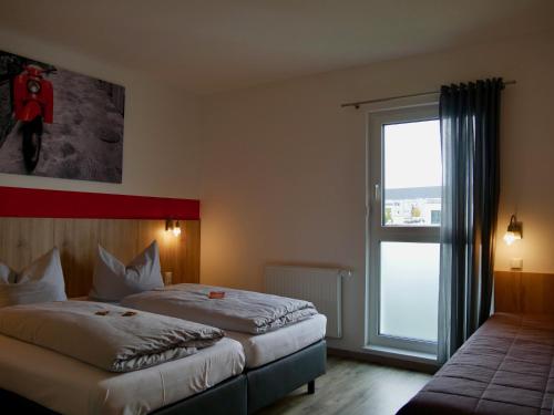 Hotel Hohenloher Tor في Bretzfeld: غرفة فندقية بسريرين ونافذة