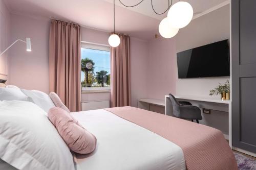 una camera da letto con un letto, una scrivania e una televisione di Villa Contessina by SeeAdria Agency a Novigrad Istria