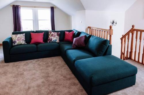 um sofá verde numa sala de estar com uma janela em Stockman's Cottage em Kirkcudbright