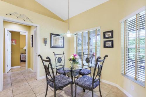 a dining room with a glass table and chairs at Pet-friendly home with pool and steps to beach/food in Marco Island