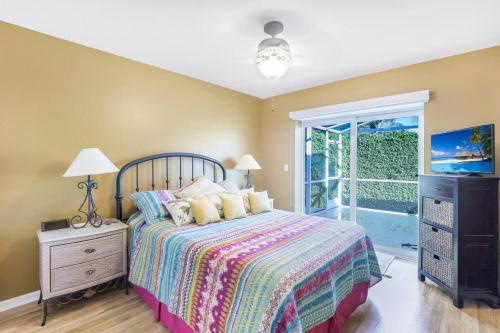 a bedroom with a bed and a tv and a window at Pet-friendly home with pool and steps to beach/food in Marco Island