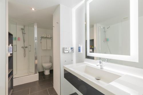 La salle de bains blanche est pourvue d'un lavabo et de toilettes. dans l'établissement Thon Hotel Brussels City Centre, à Bruxelles