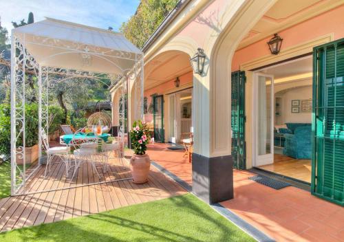 a home with a patio with a white umbrella at Villa Mares - sea view, free garage in Rapallo