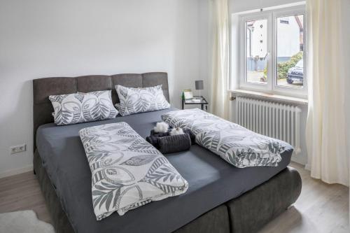 a bed with pillows on it in a room with a window at Ferienwohnung Holly in Ebringen