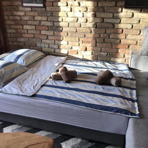 a bed in a room with a brick wall at Midana Vrdnik in Vrdnik