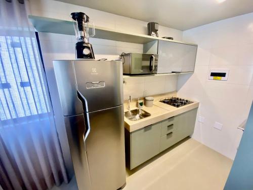 a kitchen with a stainless steel refrigerator and a stove at Edifício Top Unique ER Hospedagens in Maceió