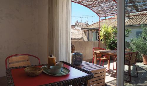 d'une table et de chaises sur un balcon avec vue sur le patio. dans l'établissement La Maison Jasmin, à Arles