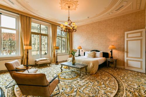 a hotel room with a bed and a chandelier at Grand Boutique Hotel-Restaurant Huis Vermeer in Deventer