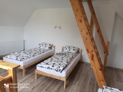 two beds in a room with a staircase at Apartameny Wiktoria i Nikola w Karwiku in Pisz