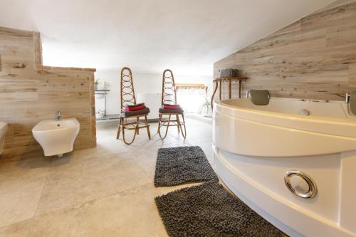 a bathroom with a tub and a sink at GardaBeds Adults Only in Castelnuovo del Garda