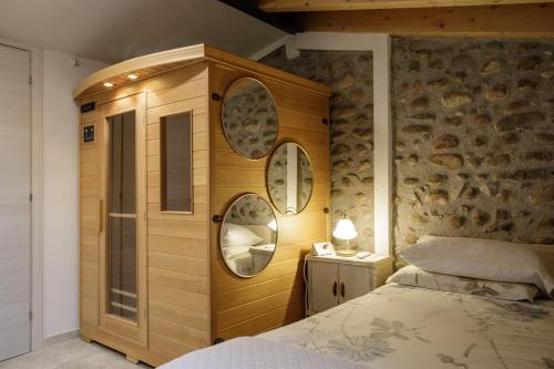 a bedroom with a wooden cabinet and a bed at GardaBeds Adults Only in Castelnuovo del Garda