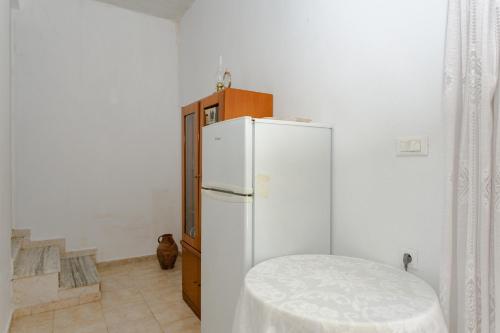 a white refrigerator in a room with a table at Hari’s House in Archangelos