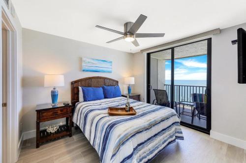 a bedroom with a bed and a balcony at Charming beachfront condo with pool, spa and views in Marco Island