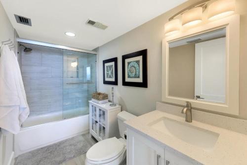 a bathroom with a toilet and a sink and a shower at Charming beachfront condo with pool, spa and views in Marco Island