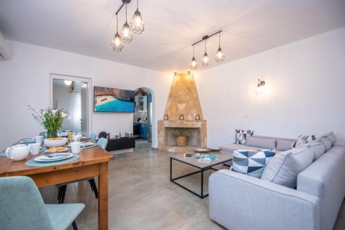 a living room with a couch and a table and a fireplace at Green Oak Villa in Orthoniaí