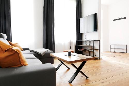ein Wohnzimmer mit einem Sofa und einem Couchtisch in der Unterkunft Be in Berlin Apartments im Bergmannkiez in Berlin