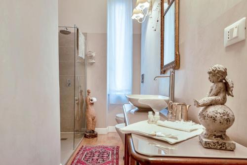 a bathroom with a sink and a shower with a statue at Suite Royal in La Spezia