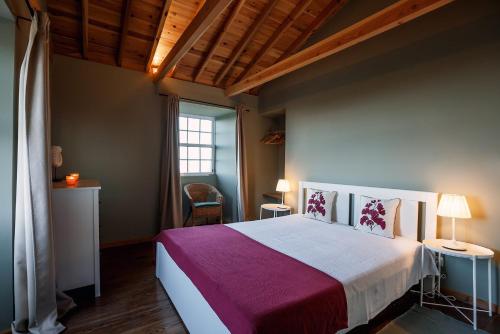 a bedroom with a large bed and a window at Liiiving in Açores - Ocean View House in Canto da Areia