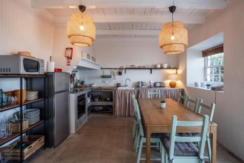 una cucina con tavolo in legno e una sala da pranzo di Liiiving in Açores - Ocean View House a Canto da Areia