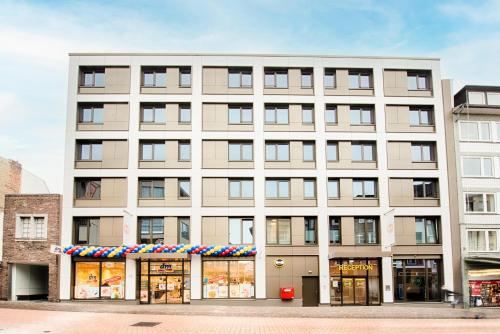 ein großes weißes Gebäude mit Ladefront in der Unterkunft B&B Hotel Aachen-City in Aachen