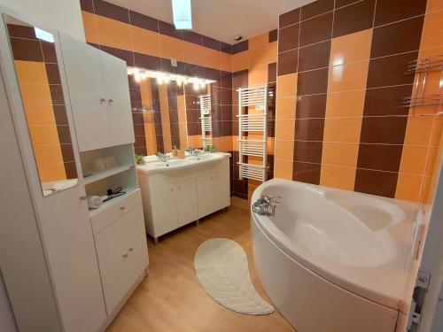 La salle de bains est pourvue d'une baignoire, d'un lavabo et de toilettes. dans l'établissement Luxury Loft Lourdes, à Lourdes