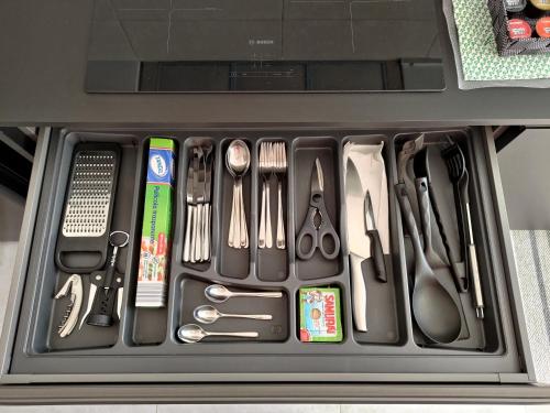 un cajón lleno de utensilios en un recipiente en Design apartment n. 41 en Trento