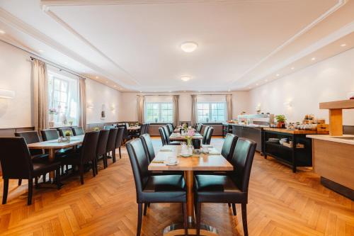 a restaurant with tables and chairs in a room at Schieners Hotel & Apfelhof Apartments in Wemding