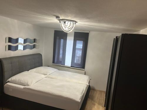 ein kleines Schlafzimmer mit einem Bett und einem Fenster in der Unterkunft Ferienwohnung Schwarzwald in Pforzheim