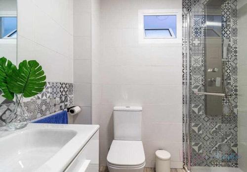 a white bathroom with a toilet and a shower at Apartamento 1 en Estadio Sevilla 8 plazas y metro in Seville
