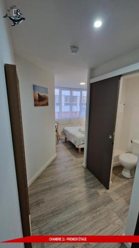 a room with a bathroom with a bed and a toilet at Hôtel Au Valéry in Sète