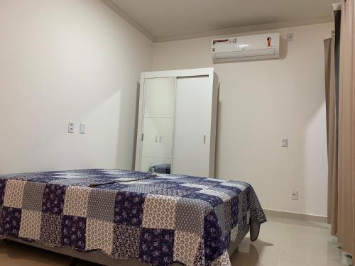 1 dormitorio con 1 cama con manta a cuadros en Casa de luxo à beira-mar de Prado, na Bahia, en Prado