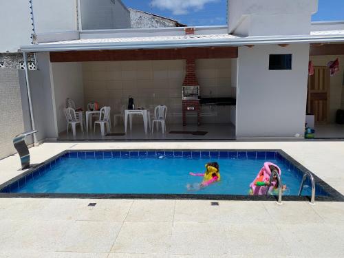 Dos muñecas están jugando en una piscina en Casa de luxo à beira-mar de Prado, na Bahia, en Prado
