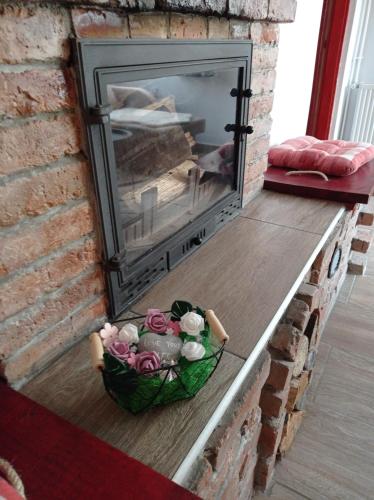 a basket of flowers in front of a fireplace at BORINA VENDÉGHÁZ in Sátoraljaújhely