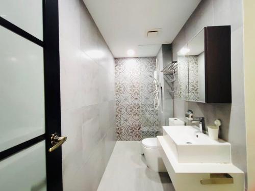 uma casa de banho com um WC branco e um lavatório. em Arte Mont Kiara by Autumn Suites Premium Stay em Kuala Lumpur