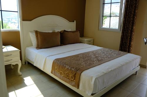 a bedroom with a large white bed with two windows at Enda Boutique Hotel Kalkan in Kalkan